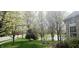 View of backyard pond with fountain, trees, and lush lawn at 13648 Seven Oaks Dr, Fishers, IN 46038