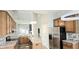 Open kitchen with granite countertops, stainless steel appliances, island, and modern lighting fixtures at 13648 Seven Oaks Dr, Fishers, IN 46038