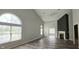 Inviting living room featuring vaulted ceilings, a cozy fireplace, and large windows for ample natural light at 13648 Seven Oaks Dr, Fishers, IN 46038