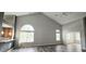 Open living room showcasing vaulted ceilings, hardwood floors, and plentiful natural light through large windows at 13648 Seven Oaks Dr, Fishers, IN 46038