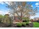 Manicured backyard showcasing a brick exterior, outdoor seating, stone fireplace, and lush landscaping at 13682 Frenchmans Creek, Carmel, IN 46032