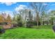 Expansive backyard featuring a well-maintained lawn, mature trees, outdoor fireplace, and privacy fence at 13682 Frenchmans Creek, Carmel, IN 46032