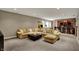 Finished basement boasts a large sectional, leather ottoman, a custom wet bar, and a vintage arcade game at 13682 Frenchmans Creek, Carmel, IN 46032