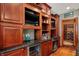 The basement wet bar is finished with granite countertops, custom cabinetry, wine fridge, TVs and display shelves at 13682 Frenchmans Creek, Carmel, IN 46032
