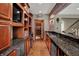 Finished basement wet bar features granite countertops, custom cabinetry with bar fridge and a doorway to the wine cellar at 13682 Frenchmans Creek, Carmel, IN 46032