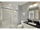 Modern bathroom featuring glass enclosed shower, vanity with dark countertop, and decorative mirror at 13682 Frenchmans Creek, Carmel, IN 46032