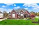Beautiful two-story red brick home features lush landscaping and a well-manicured lawn at 13682 Frenchmans Creek, Carmel, IN 46032