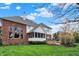 Exterior view of a brick home with a screened porch, stone patio, green lawn, and mature trees at 13682 Frenchmans Creek, Carmel, IN 46032