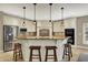 Beautiful kitchen with a central island, granite counters, stainless steel appliances and pendant lights at 13682 Frenchmans Creek, Carmel, IN 46032