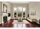 Bright living room featuring a fireplace, large windows, and hardwood floors at 13682 Frenchmans Creek, Carmel, IN 46032