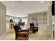 Spacious living room featuring leather armchairs, fireplace, and seamless flow to the dining area at 13682 Frenchmans Creek, Carmel, IN 46032