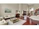 Spacious living room featuring hardwood floors, a piano, and staircase in the background at 13682 Frenchmans Creek, Carmel, IN 46032