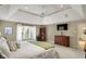 Comfortable main bedroom with large windows, a tray ceiling, and stylish furnishings at 13682 Frenchmans Creek, Carmel, IN 46032