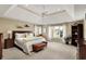 Spacious main bedroom featuring a tray ceiling, ceiling fan, and large windows at 13682 Frenchmans Creek, Carmel, IN 46032