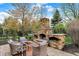 Outdoor patio featuring a stone fireplace, seating area, and meticulously maintained landscaping at 13682 Frenchmans Creek, Carmel, IN 46032
