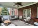 Enjoy the outdoors in this screened porch with brick accent wall, cozy seating, and ceiling fan at 13682 Frenchmans Creek, Carmel, IN 46032