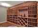 The wine cellar showcases custom shelving and brick accents, and is well-lit in this home's finished basement at 13682 Frenchmans Creek, Carmel, IN 46032