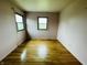 A bright bedroom featuring hardwood floors, two windows, and neutral wall color at 1387 W Furry Rd, Fountaintown, IN 46130