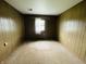 Bedroom features paneled walls, beige carpet, and a single window with white sheer curtains at 1387 W Furry Rd, Fountaintown, IN 46130