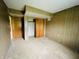 This bedroom has paneled walls, carpeted flooring, and a closet with double doors at 1387 W Furry Rd, Fountaintown, IN 46130
