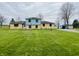 Spacious home featuring a large green lawn, mature trees, and a light blue storage shed at 1387 W Furry Rd, Fountaintown, IN 46130