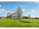 Expansive backyard with lush green lawn, bordered by mature trees and neighboring homes under a blue sky at 14814 Edgebrook Dr, Fishers, IN 46040