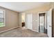 Carpeted bedroom with neutral walls, large window, and doorways to an en suite bathroom and hallway at 14814 Edgebrook Dr, Fishers, IN 46040
