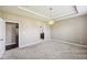 Neutral carpeted bedroom with a tray ceiling, chandelier, neutral color walls, and open doorway at 14814 Edgebrook Dr, Fishers, IN 46040