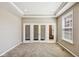 Bright home office featuring glass panel double doors, neutral paint, carpet, and a large window at 14814 Edgebrook Dr, Fishers, IN 46040