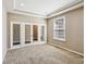 Bright home office featuring glass panel double doors, neutral paint, carpet, and a large window at 14814 Edgebrook Dr, Fishers, IN 46040