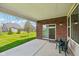 Covered patio featuring a brick wall, sliding glass door, and outdoor seating area with lush green lawn at 14814 Edgebrook Dr, Fishers, IN 46040