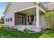 Covered patio with brick accents, neutral siding, and decorative string lights, offering a cozy outdoor space at 14814 Edgebrook Dr, Fishers, IN 46040