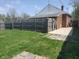 A grassy backyard with a wooden fence, the side of the house can be seen at 1640 Lawton Ave, Columbus, IN 47201