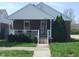 Inviting brick home with a charming covered front porch, complete with white railings and flower boxes at 1640 Lawton Ave, Columbus, IN 47201