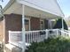 Charming brick home featuring a cozy covered front porch, flower boxes, and white railings at 1640 Lawton Ave, Columbus, IN 47201