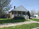 Delightful brick home with a covered front porch, white railings, and a lush green yard at 1640 Lawton Ave, Columbus, IN 47201