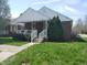 Charming brick home featuring a covered front porch with white railings and well-manicured lawn at 1640 Lawton Ave, Columbus, IN 47201