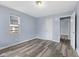 Bedroom with blue walls, wood-look flooring, natural light, and white doors at 1739 N Alton Ave, Indianapolis, IN 46222