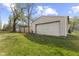 A detached garage with a large white door, set among green grass and trees at 1739 N Alton Ave, Indianapolis, IN 46222