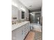 Bathroom featuring dual sinks, decorative tile floor, and tiled shower with glass doors at 1792 Salina Dr, Avon, IN 46123