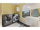 Bright laundry room with modern washer and dryer, sink, and natural light at 1792 Salina Dr, Avon, IN 46123