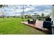 Expansive back yard featuring a spacious wooden deck with outdoor dining and seating area overlooking a large grassy field at 18017 Gasparilla Ct, Westfield, IN 46062