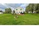Expansive backyard featuring a large grassy area, a wooden deck, a stone fire pit, and mature trees at 18017 Gasparilla Ct, Westfield, IN 46062