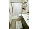 Bright bathroom featuring a shower with a curtain, stylish wood shelves, and a modern vanity with essential toiletries at 18017 Gasparilla Ct, Westfield, IN 46062