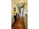 Inviting hallway with hardwood floors, decorative table with mirror and decor, and easy access to rooms and staircase at 18017 Gasparilla Ct, Westfield, IN 46062