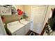Functional laundry room with a full-size washer and dryer, shelving for storage, and a convenient access door at 18017 Gasparilla Ct, Westfield, IN 46062