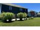 Backyard showcasing a patio, lush lawn, mature landscaping, and the home's dark siding at 18488 Jaden Dr, Westfield, IN 46062