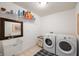 Functional laundry room with modern washer, dryer, utility sink, and ample storage space at 18488 Jaden Dr, Westfield, IN 46062