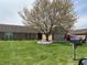 Brick home showcasing a well-manicured lawn, mature tree, and colorful flower bed at 1959 Crystal Bay East Dr, Plainfield, IN 46168