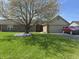 Well-maintained brick home featuring a lush lawn, mature tree, and beautiful purple flowers at 1959 Crystal Bay East Dr, Plainfield, IN 46168
